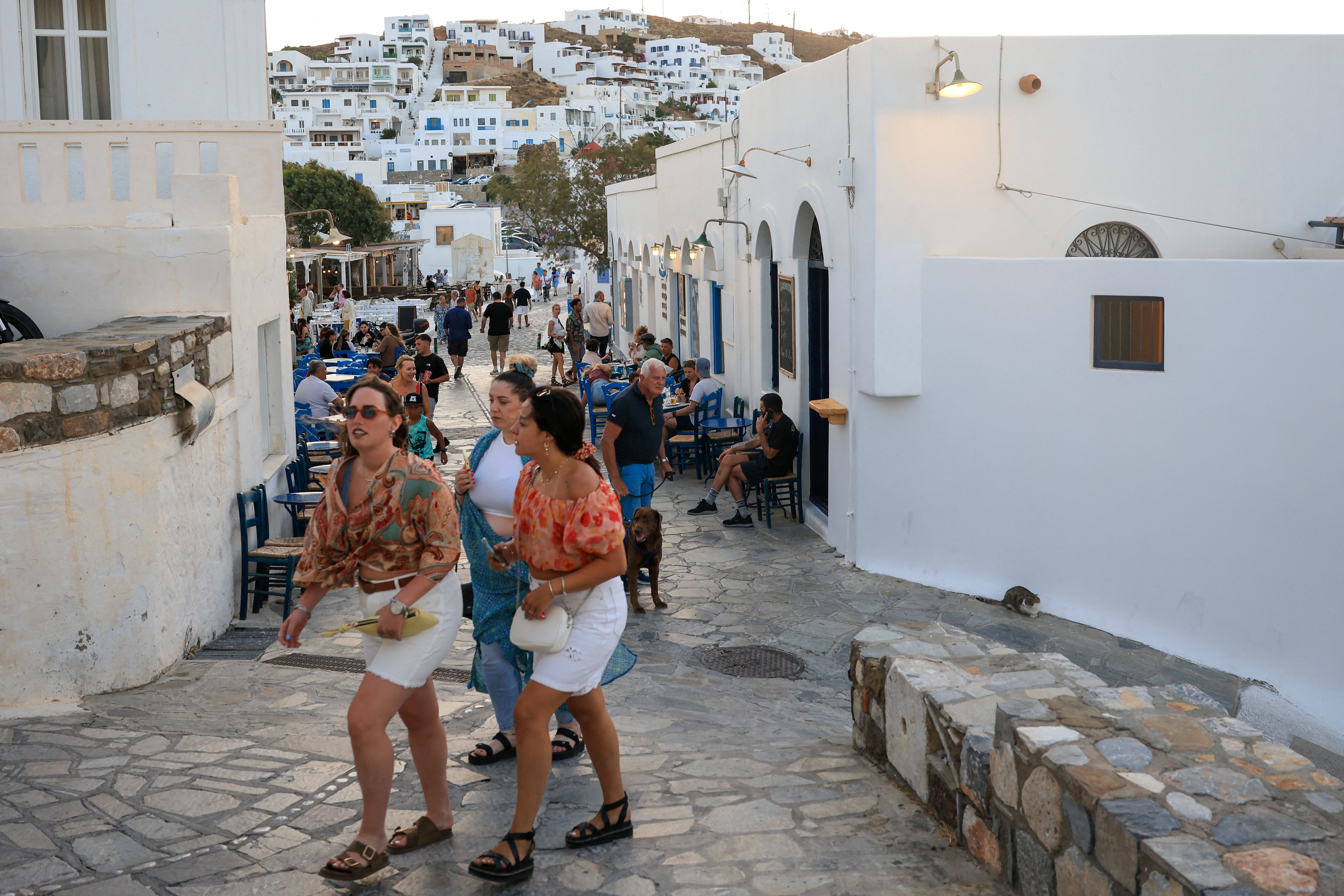 Astypalaia adasının ana kasabasında yürüyen turistler.