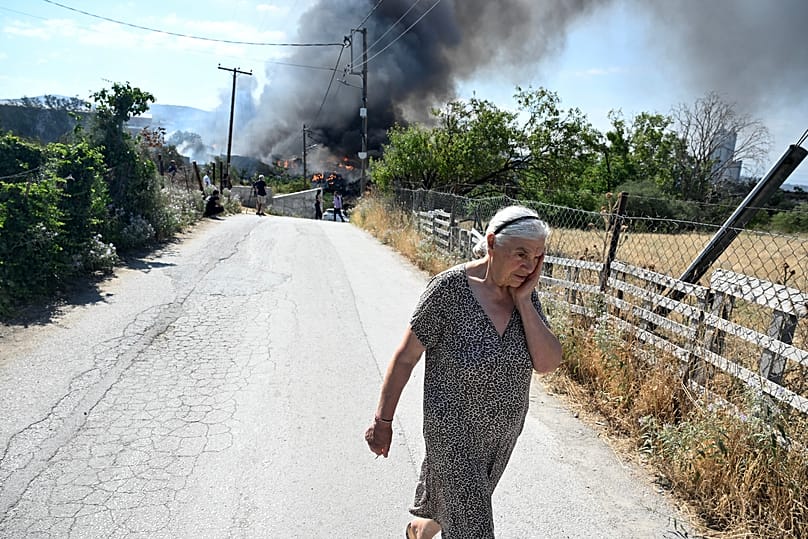 Selanik kenti yakınlarındaki bir orman yangını sırasında tepki veren bir kadın, 5 Temmuz 2026