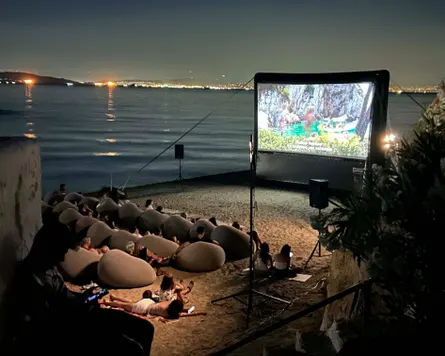 Plajda fasulye torbaları olan bir açık hava sineması.