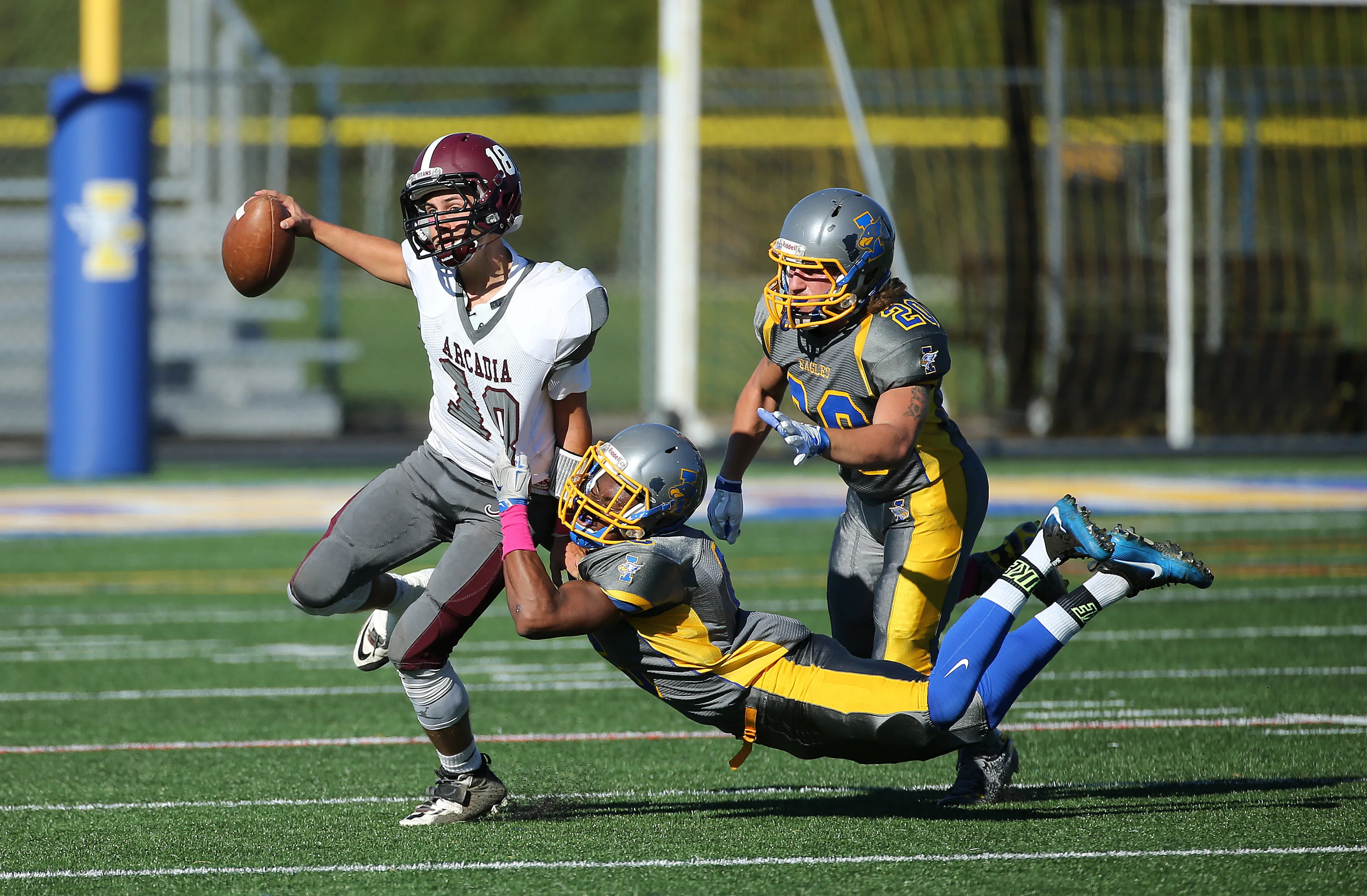 Greece Arcadia quarterback Neale McMullen is sacked by Irondequoit's Jevonte Leslie (6) and Gary Bohrer (20) during a game played in 2015.