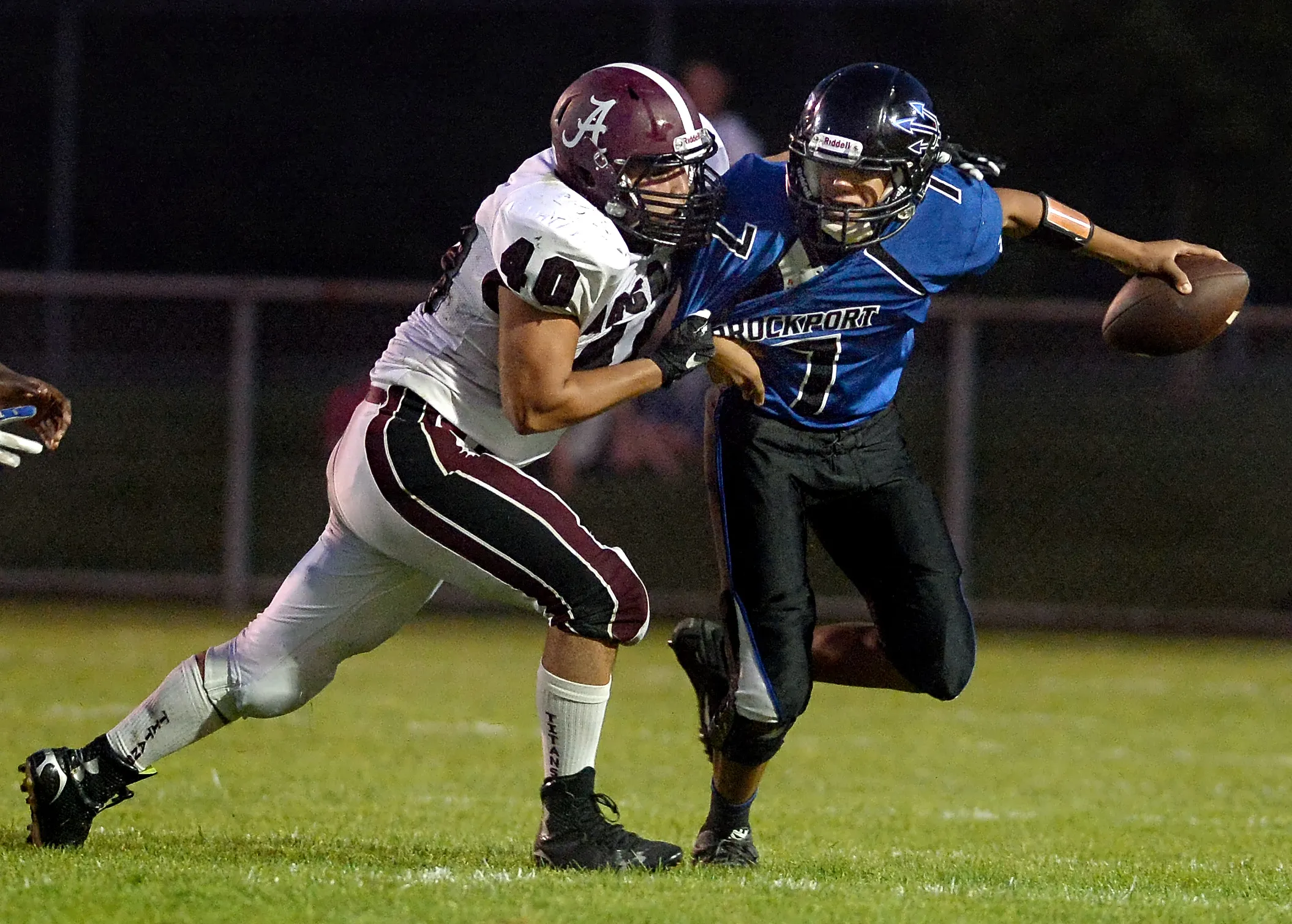 Greece Arcadia's Chuck Finocchario, left, drags down Brockport quarterback Ashton Scott during a game played on Sept. 4, 2015.